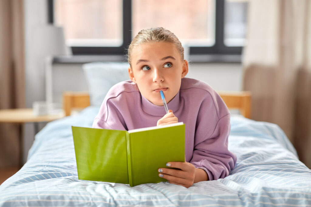 Teenager Journaling on Bed